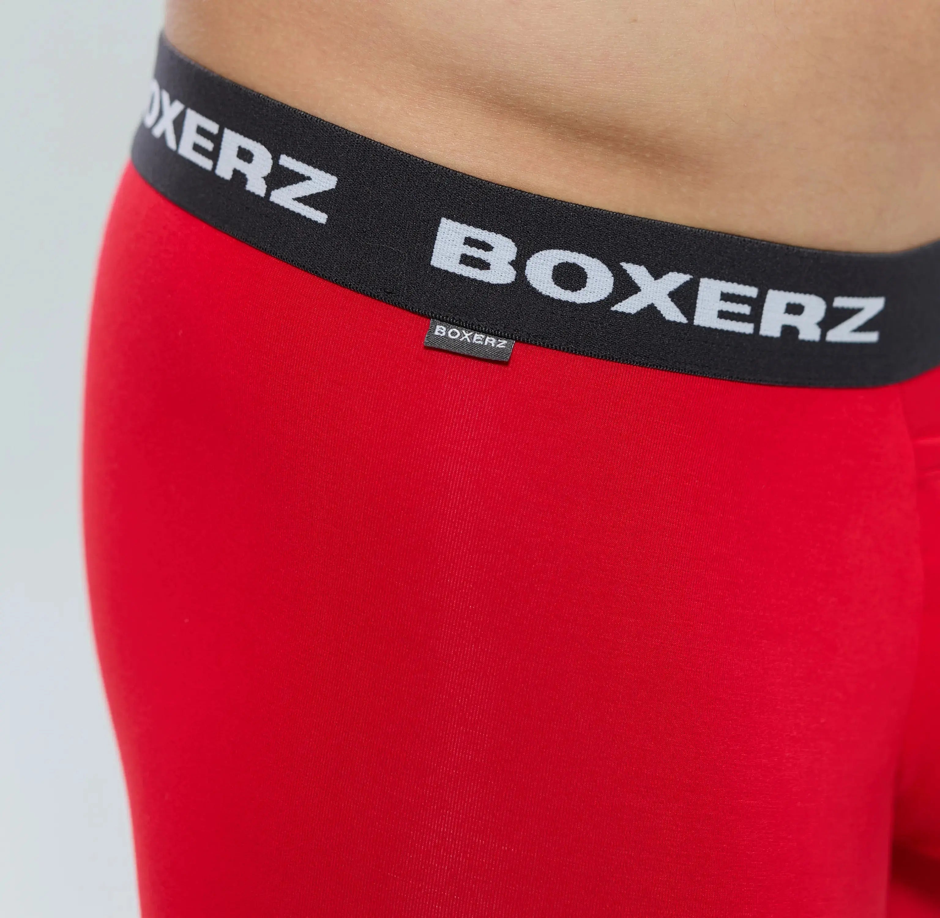 Close-up of Boxerz waistband on red boxer briefs, showing logo and stitching details