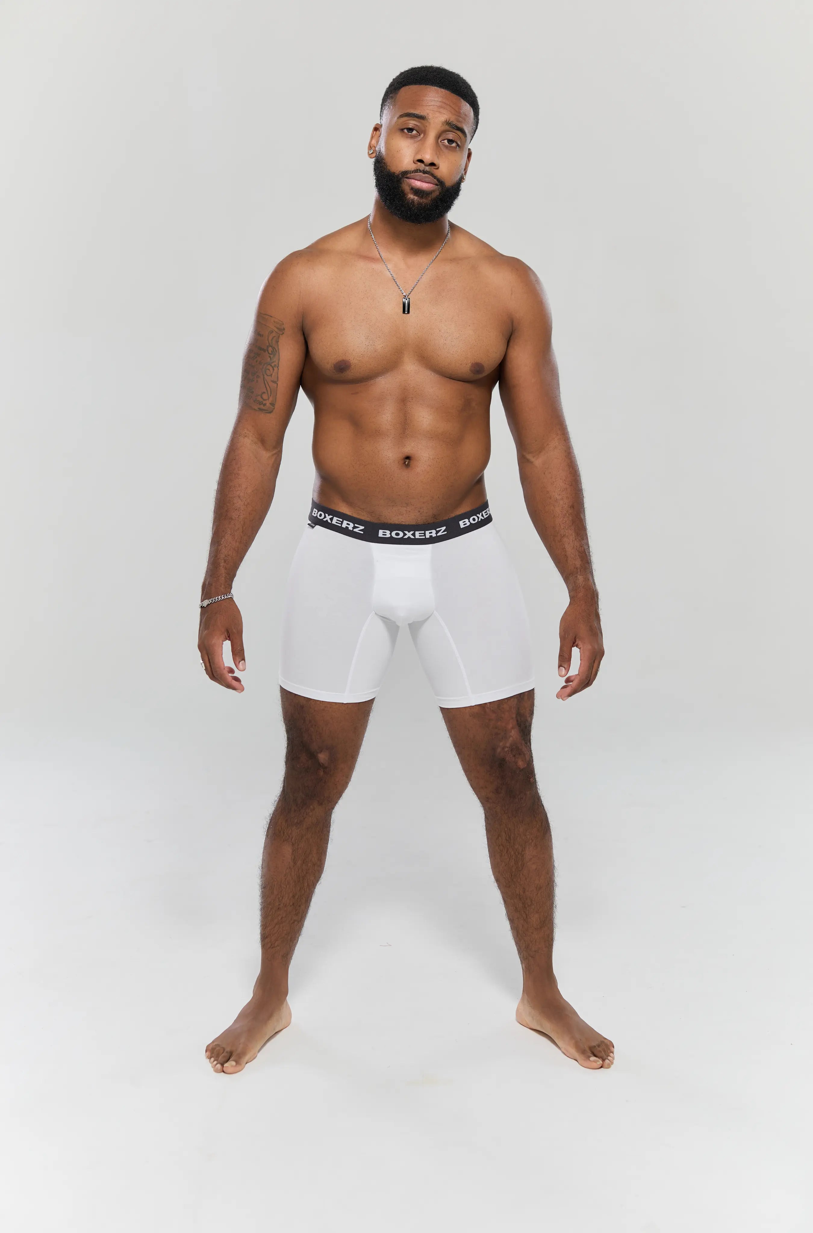 Full body front view of male model wearing white boxer briefs from Boxerz, showing tailored fit and logo waistband

