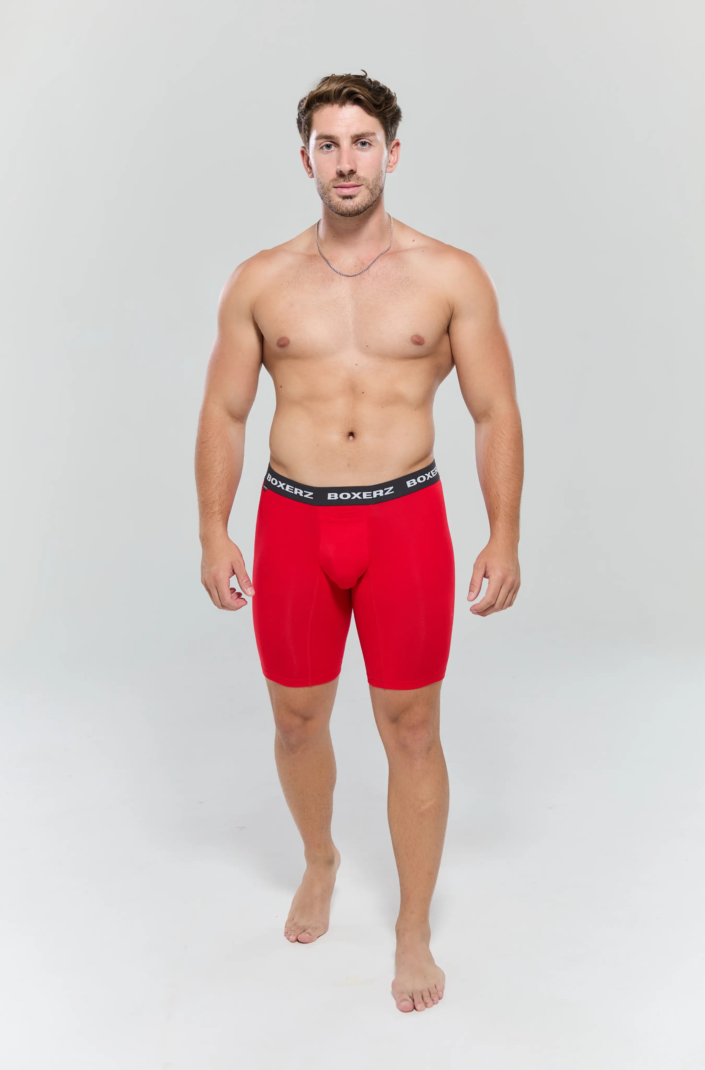 Full body front view of male model wearing red Sports+ boxer briefs from Boxerz, showing logo waistband and tailored fit